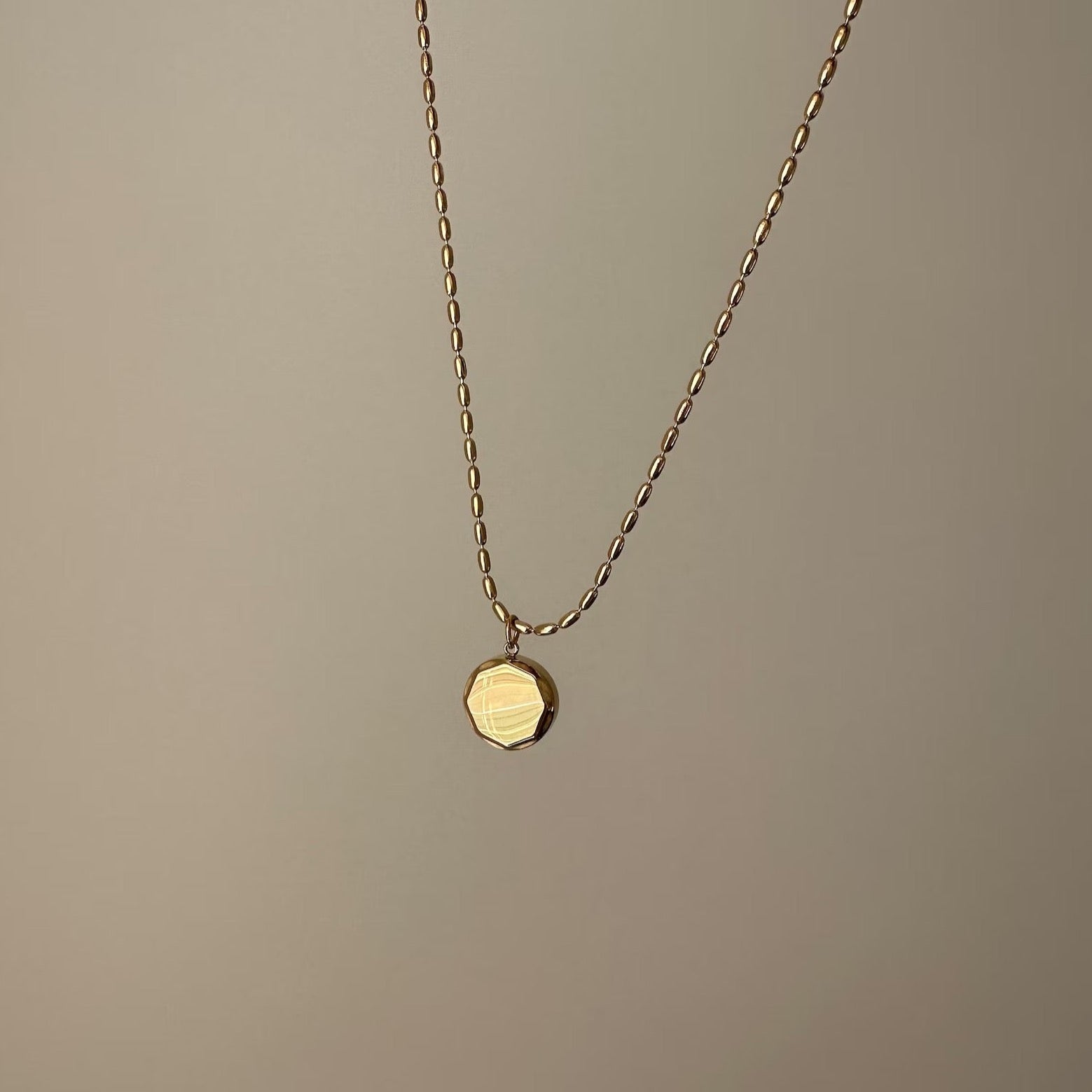 Trendy gold necklace with a nonagon coin charm