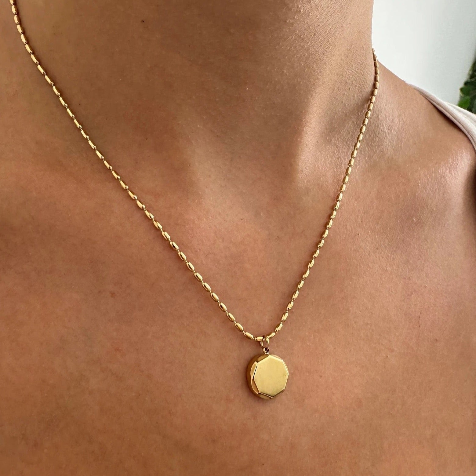 Gold coin pendant necklace with a unique nonagon shape