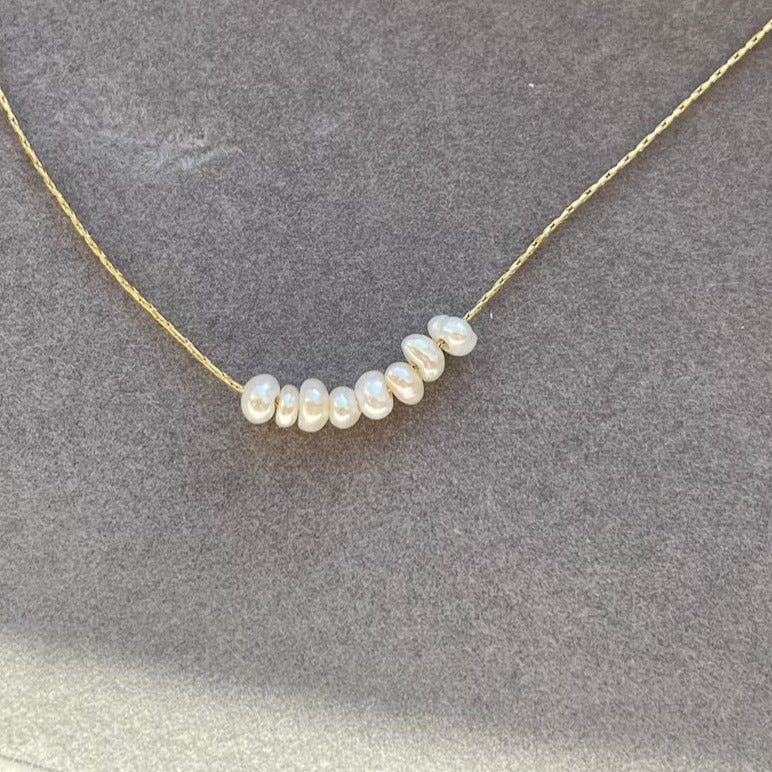 Dainty pearl bead necklace on a delicate chain.
