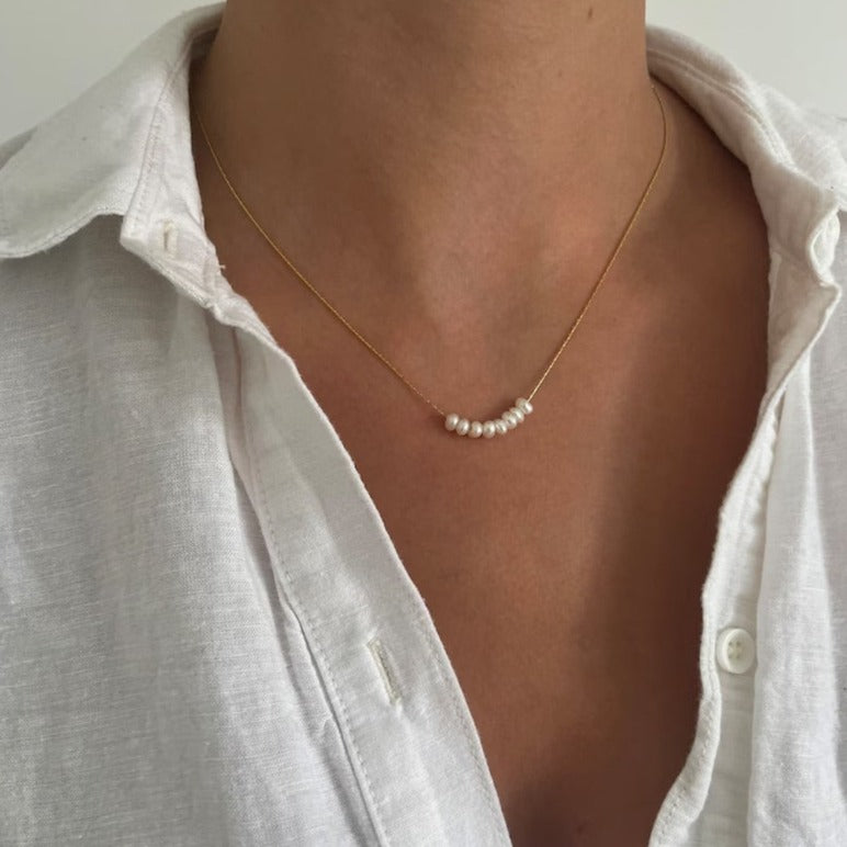 Pearl bead necklace adding a touch of elegance to any outfit.