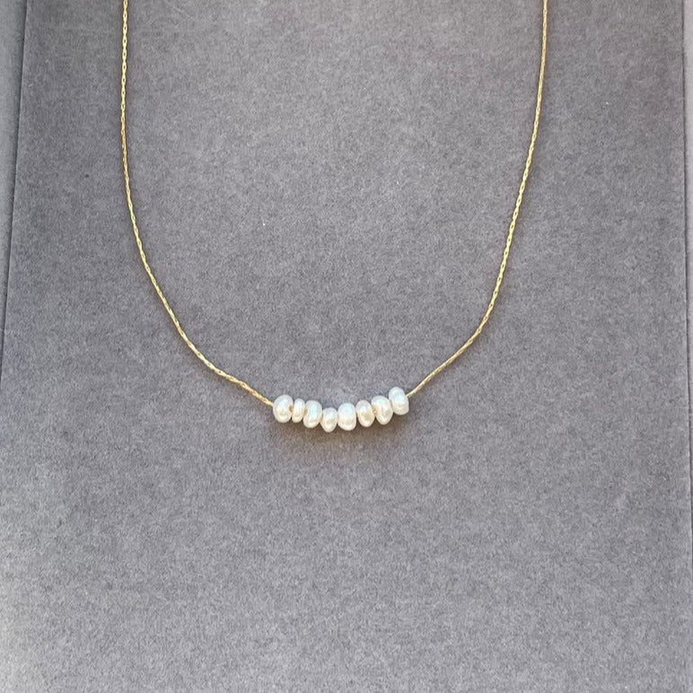 Pearl bead necklace featuring lustrous, round pearls.