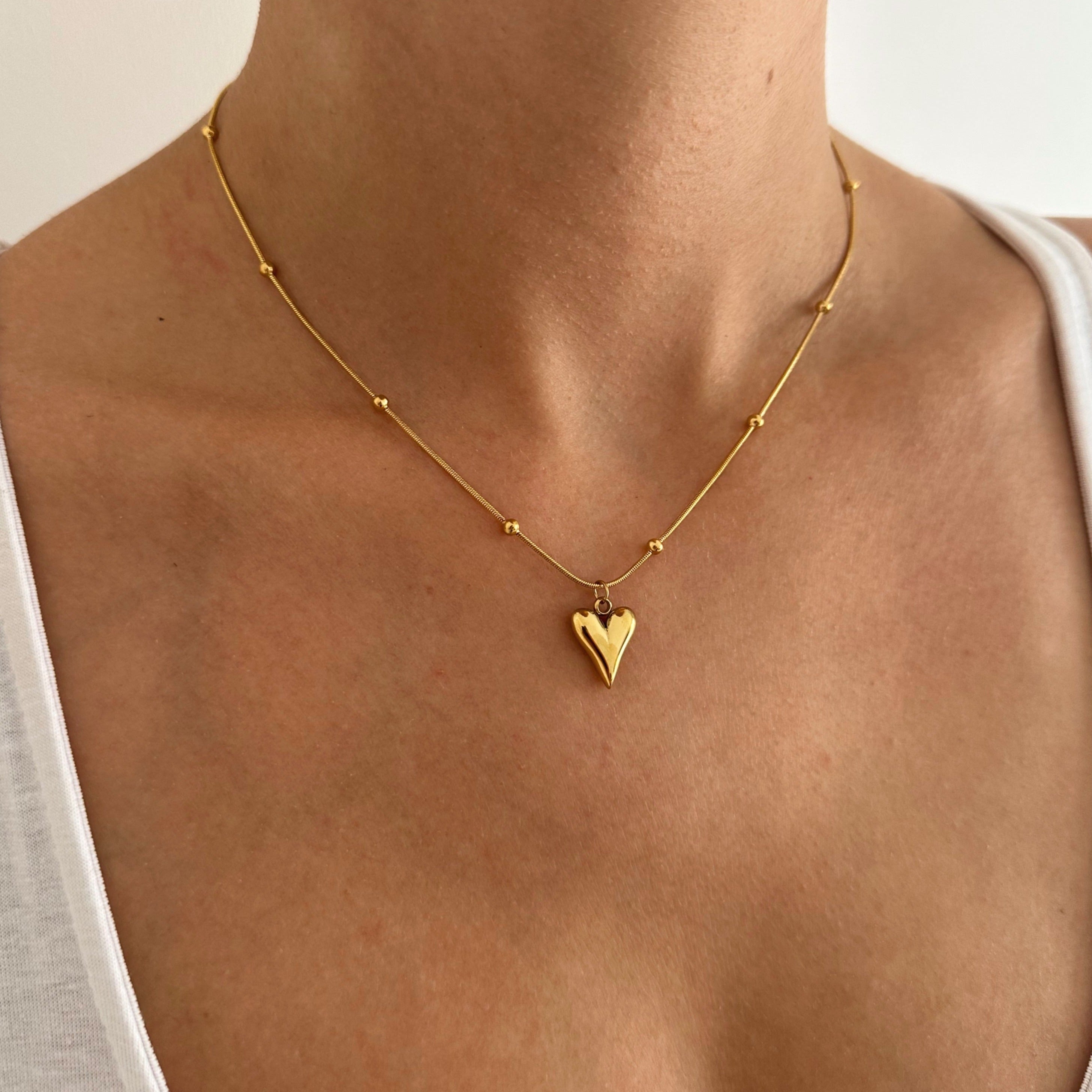 Heart Chain Necklace - Close-up of the exquisite golden heart pendant, highlighting its intricate detailing and luxurious shine against the delicate beaded chain.
