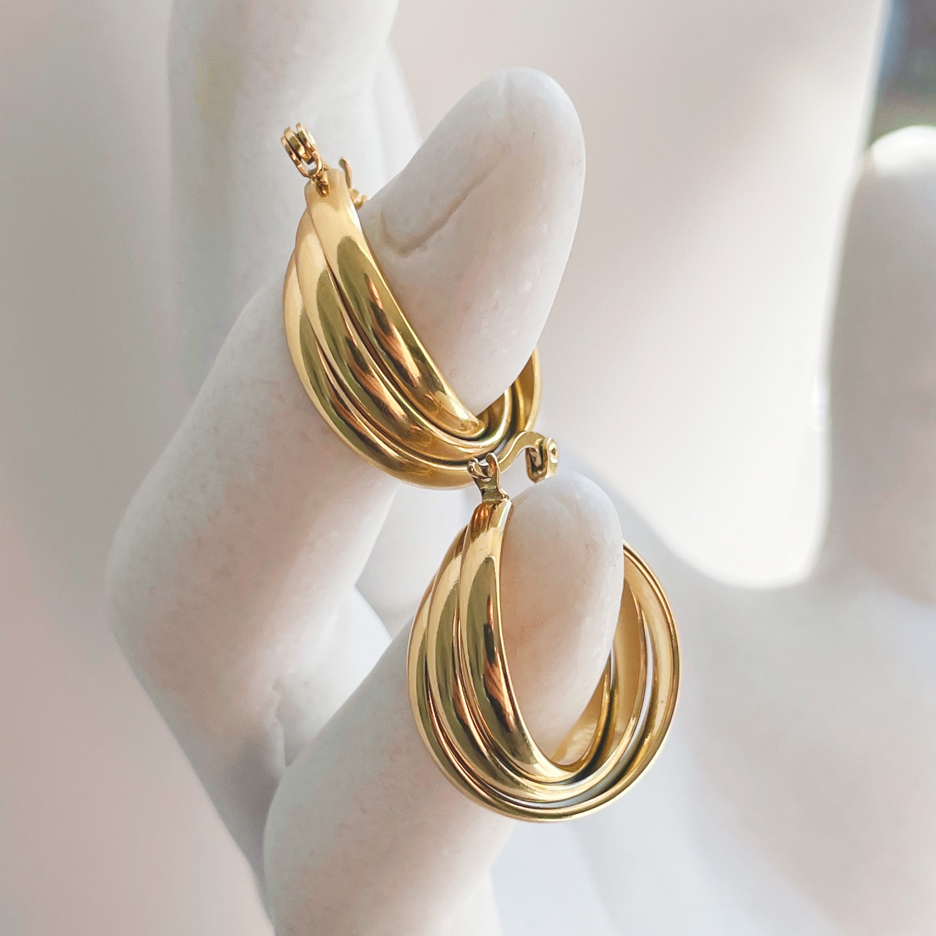 Detailed shot of playful Golden Twirl Gold Twist Hoops