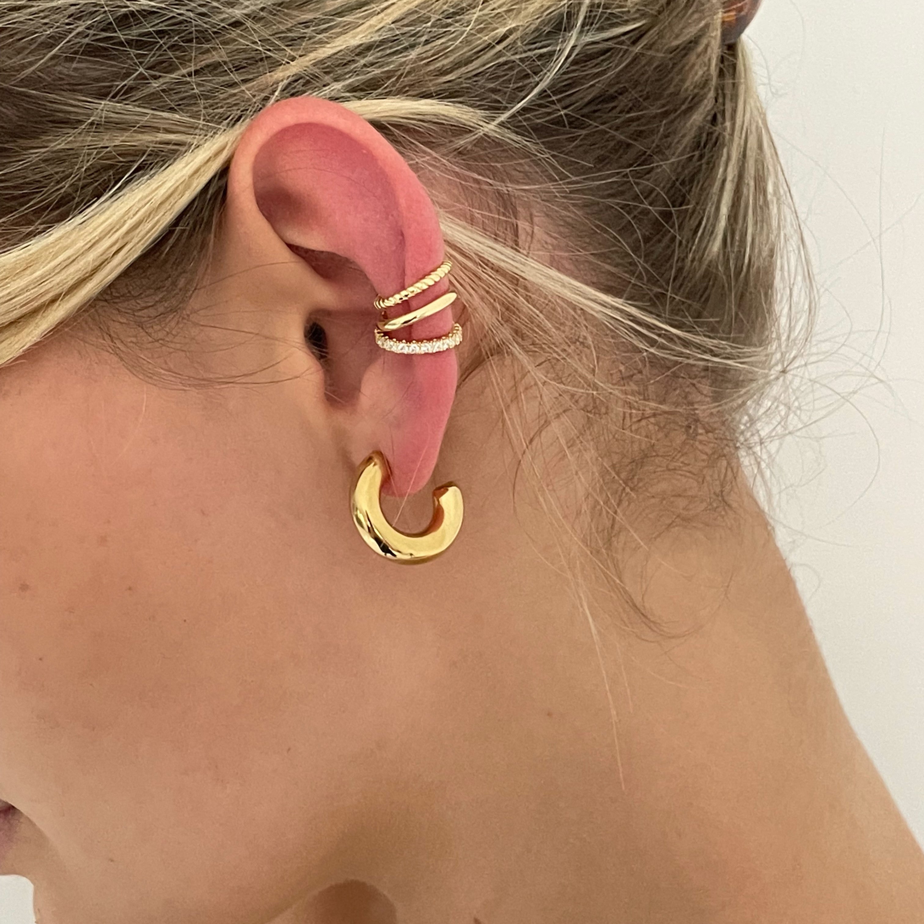 Chunky gold hoop earrings featuring intricate designs for a bold statement
