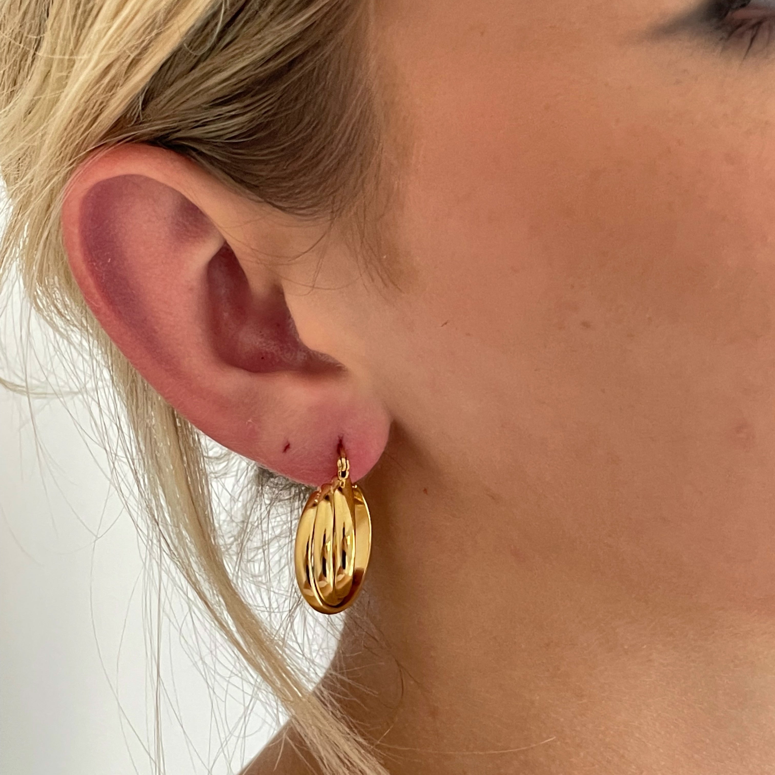 Close-up of Golden Twirl Gold Twist Hoops shining brightly