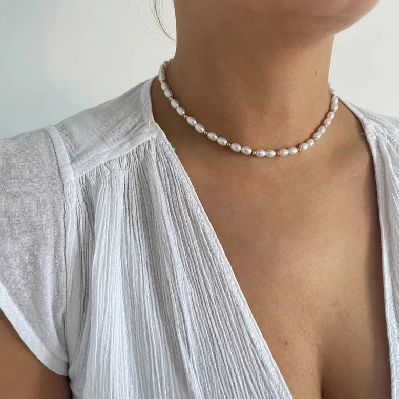 Enhance your outfit with the elegance of a gold and pearl necklace