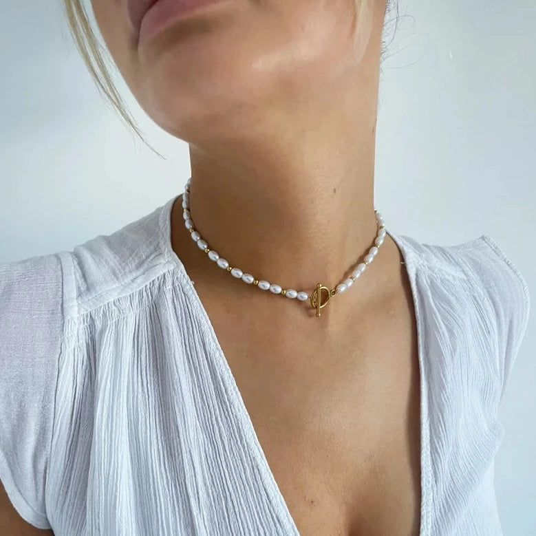 Trending jewellery for any outfit with a gold and pearl necklace.